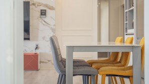 A dining area with a table and chairs, a marble wall, and a bookshelf. - Pohang Luna Ocean View Pool Villa (Pohang)