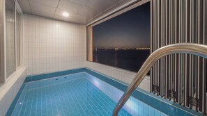 A pool area with a view of a cityscape at night. - Pohang Luna Ocean View Pool Villa (Pohang)