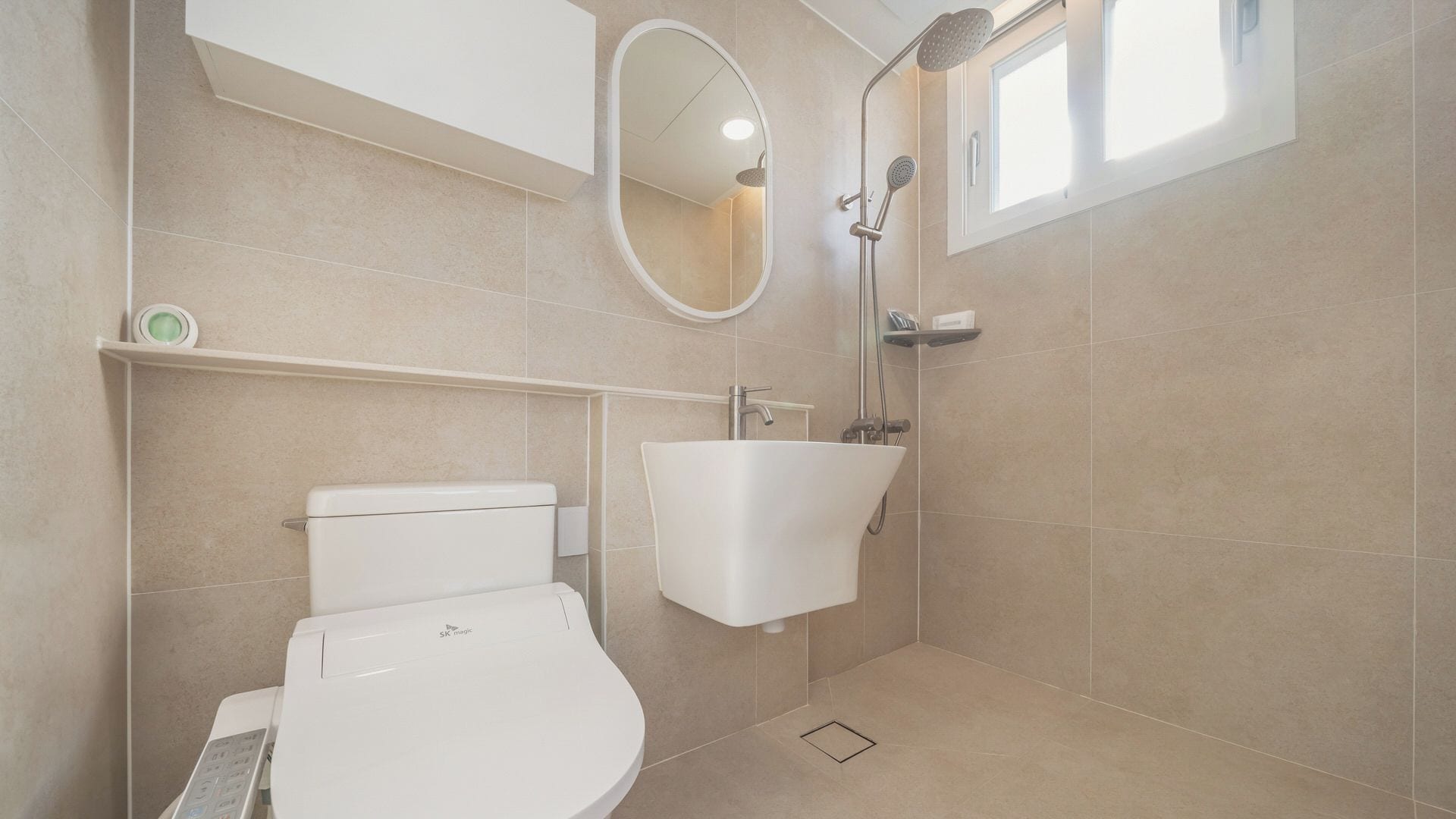 A modern bathroom with a toilet, sink, and shower.
