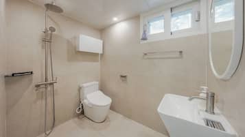 A modern bathroom with a shower, toilet, and sink.