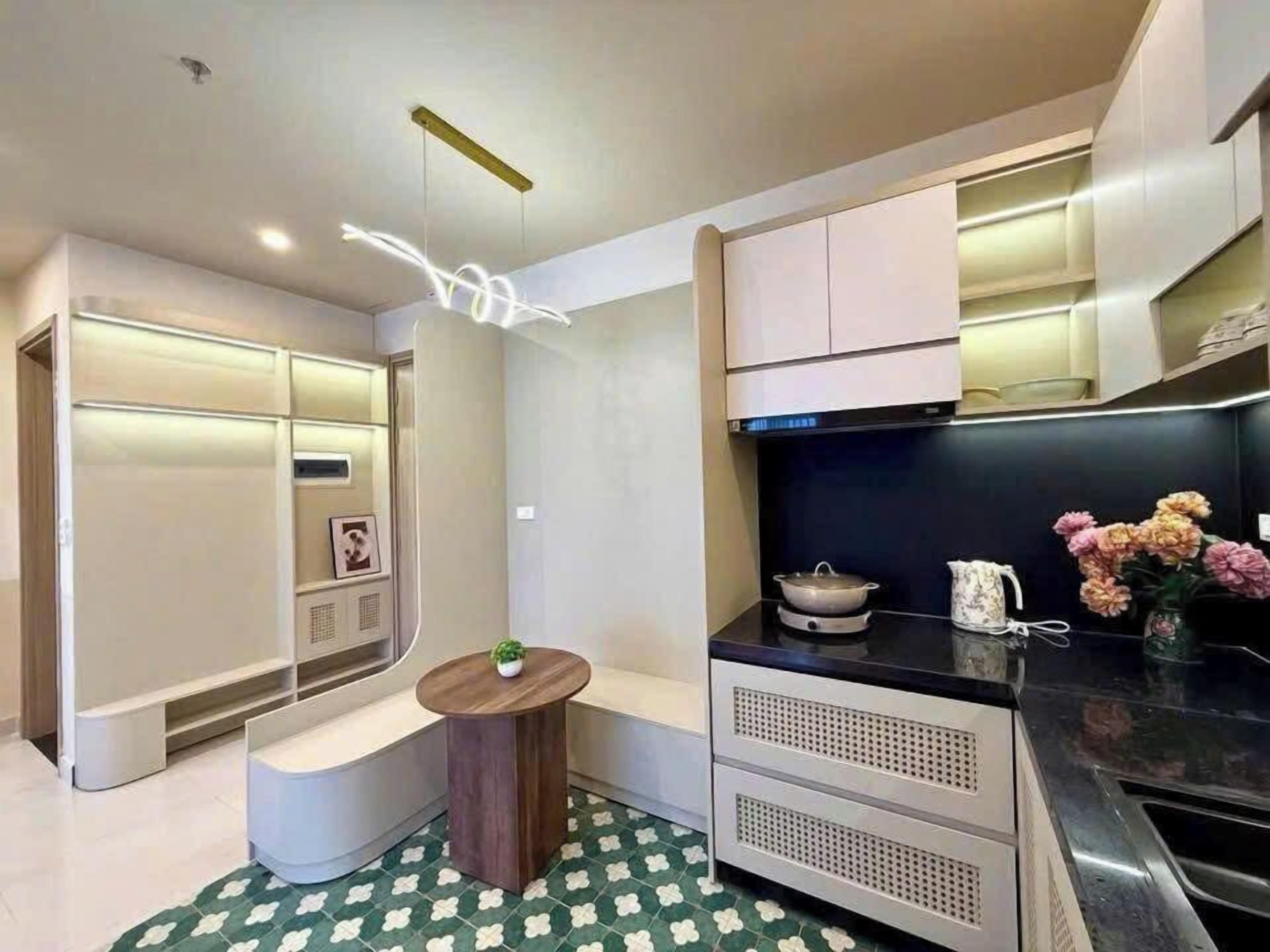 Una cocina moderna con horno empotrado, un fregadero y un pequeño comedor con una mesa redonda.