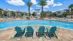 A swimming pool with lounge chairs and palm trees. - Luxury Prominence Home – Pool, Beach & Golf Cart (Inlet Beach)