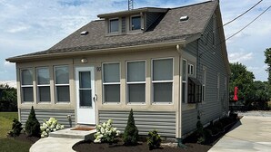 Ein eingeschossiges Haus mit Garage, einer kleinen Veranda und einem geneigten Dach.