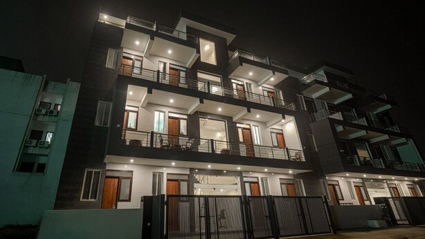 A multi-story residential building with balconies, large windows, and a gated entrance. - Aerostays Studio Apartments (Dera Bassi)