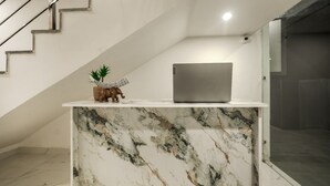 A modern interior with a marble counter, a laptop, and a small elephant figurine. - Aerostays Studio Apartments (Dera Bassi)