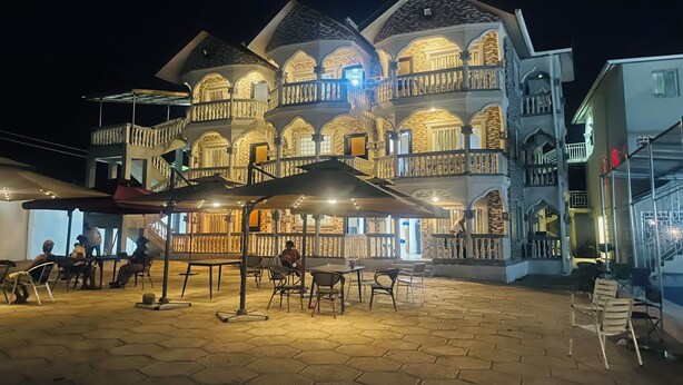 Un edificio de varios pisos con balcones y una zona de estar exterior techada.
