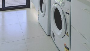A laundry room with two washing machines, a sink, and a window with a view of greenery. - Luxury Home in Countryside Setting close to Beaches, Bushland, Restaurants/Shops (North Arm)