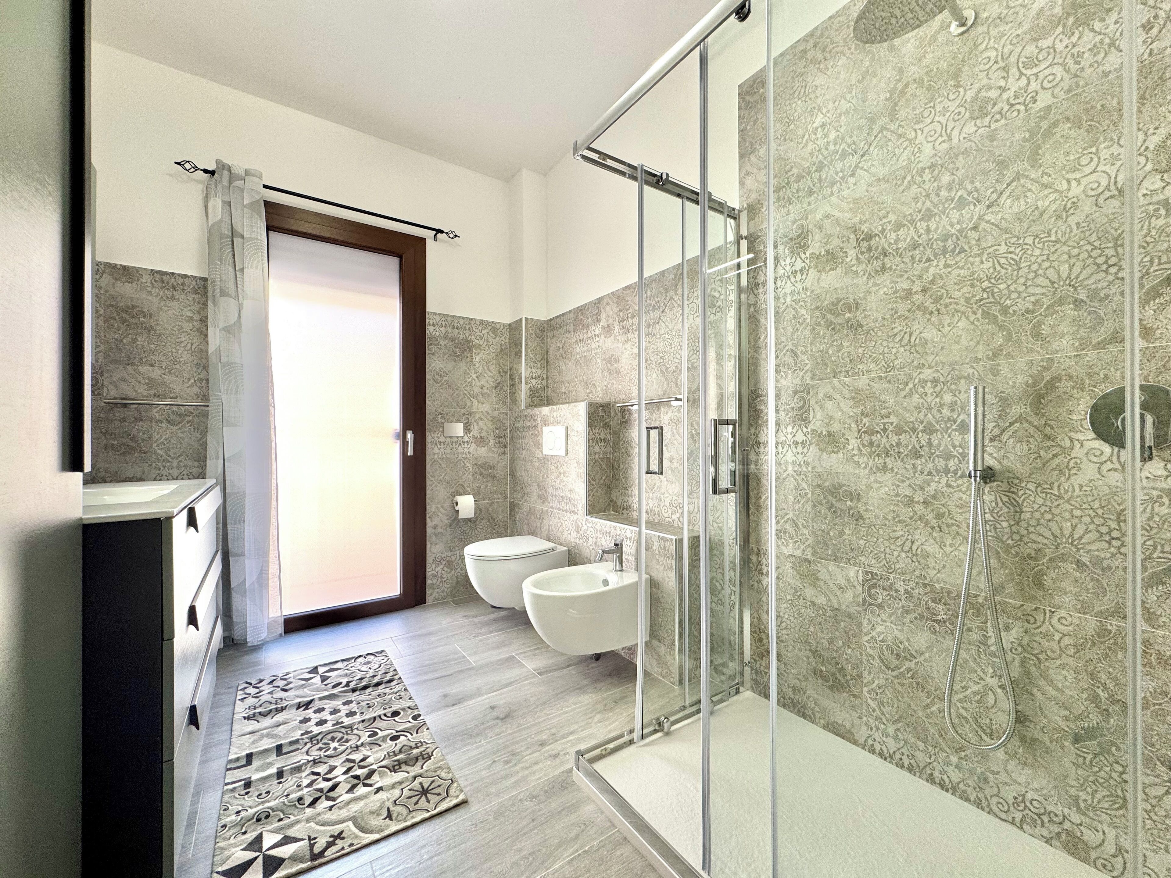 Un baño moderno con cabina de ducha de vidrio, inodoro y lavamanos.
