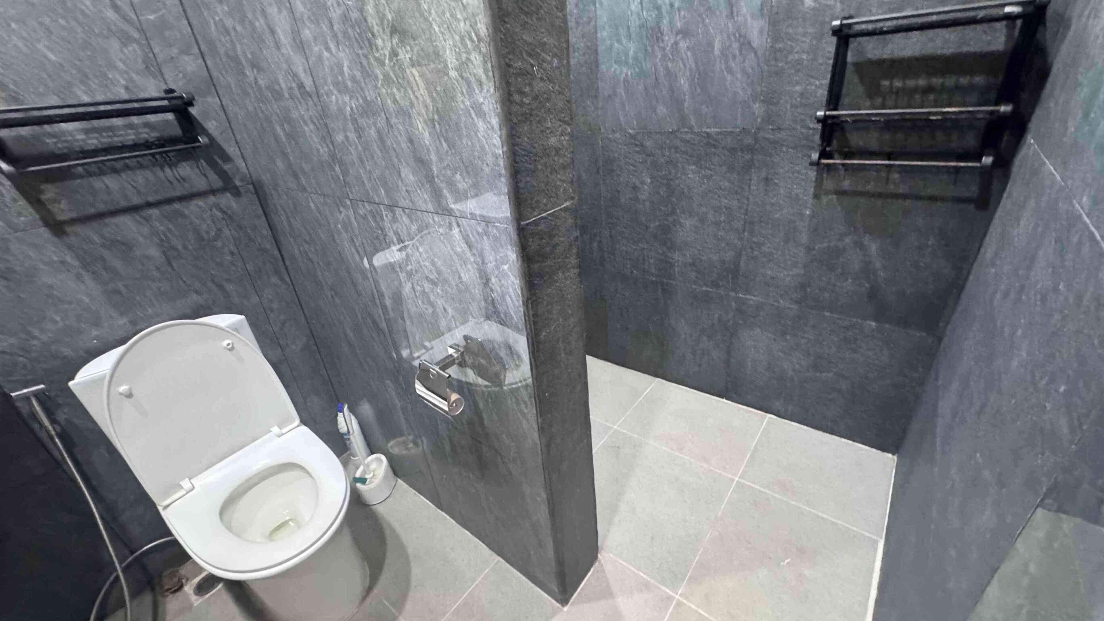 A modern bathroom with a toilet, a shower, and a sink.