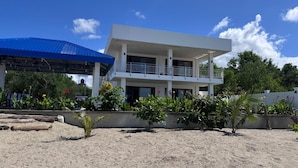A two-story building with a flat roof and a balcony on the upper floor.