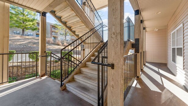 A covered outdoor staircase with a view of a residential area. - 3BR Condo at Royal Links • Golf Course Views • Near Hwy 76 (Branson)