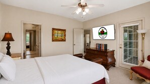 A bedroom with a bed, dresser, and a television on the wall. - 3BR Condo at Royal Links • Golf Course Views • Near Hwy 76 (Branson)