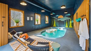 Ein Wellnessraum mit Whirlpool, Liegestühlen und Handtüchern an Haken.
