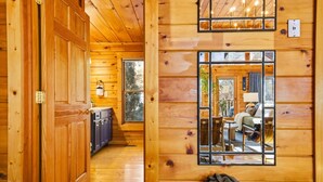 Ein Holzblockhaus-Interieur mit gemütlichem Wohnbereich, einem Essbereich und einer Küche.