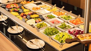 A buffet with various food options and utensils. - Golden Tulip Muscat The Village (Seeb)