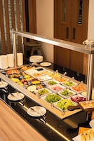 A buffet with various food options and utensils.