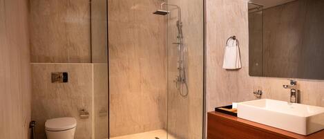 A modern bathroom with a glass-enclosed shower, a wooden vanity, and a large mirror.