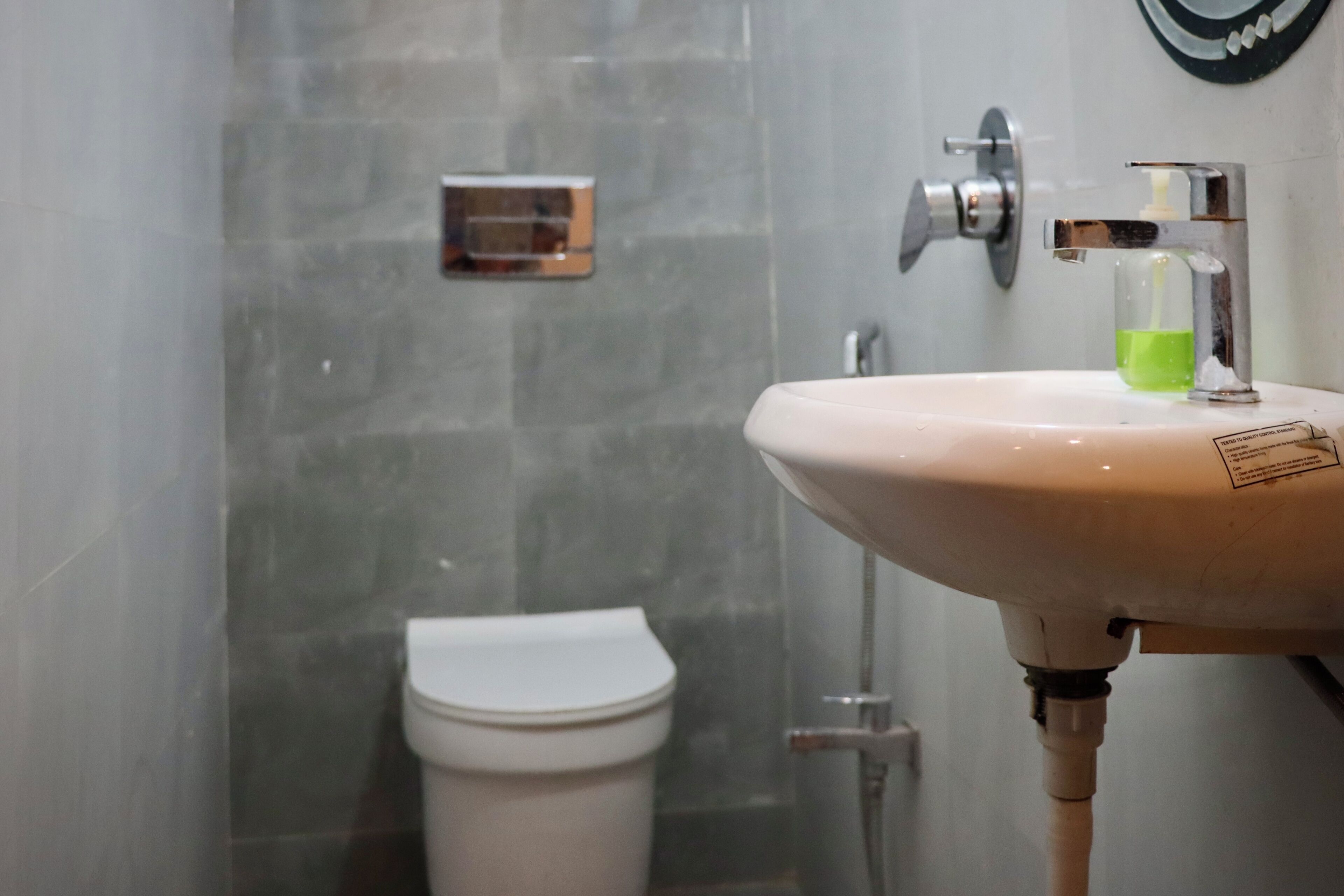 A bathroom with a white sink, a mirror, and a toilet.
