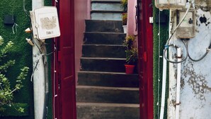 Un escalier menant à une auberge de jeunesse, sur lequel on peut lire l’inscription : « MOSAIC HOSTEL, Varanasi, Inde ».