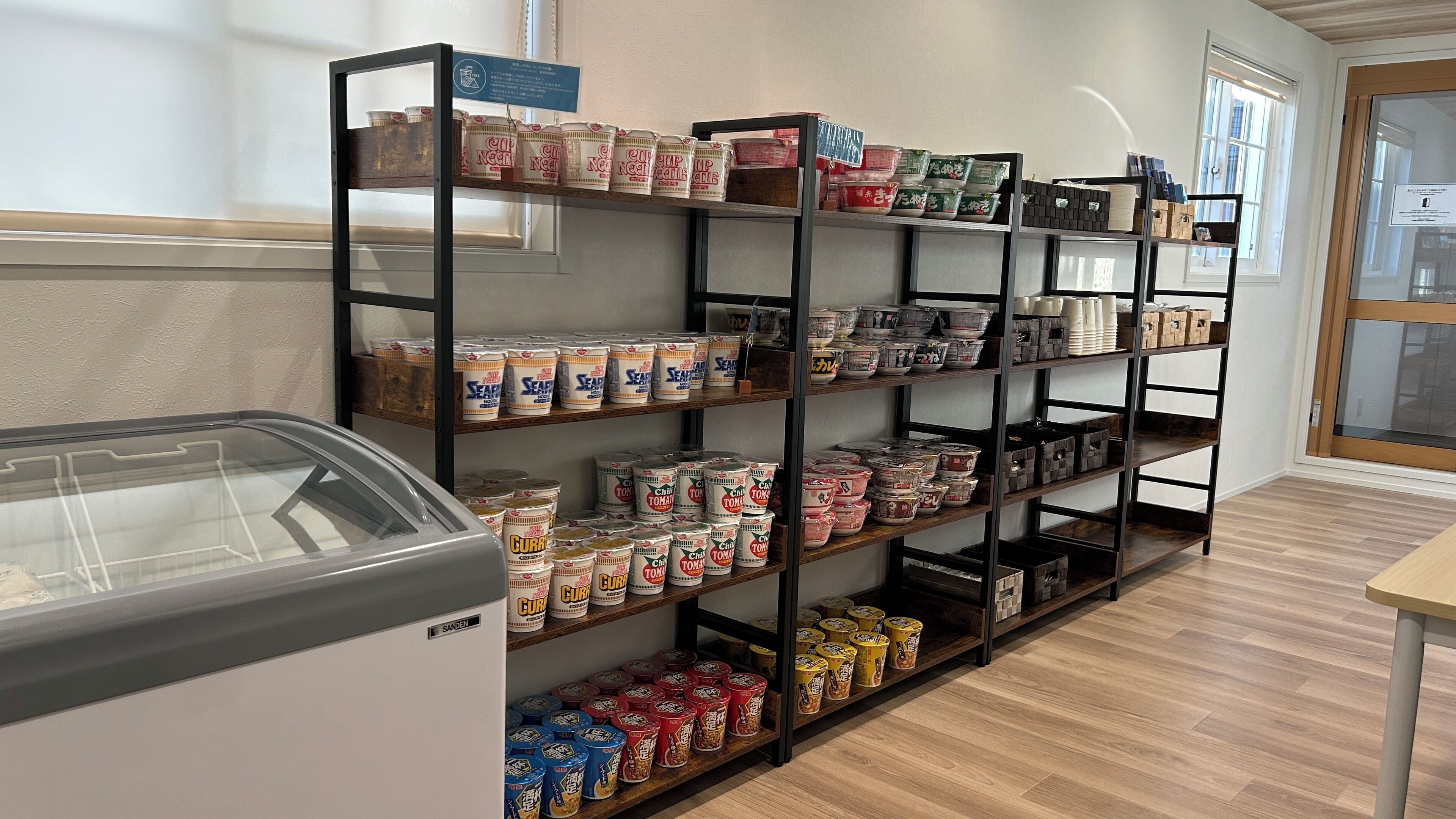 A storage area with shelves filled with canned goods and a refrigerated display case.