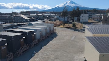 Un estacionamiento con edificios modulares, vista de una montaña y cielo despejado.