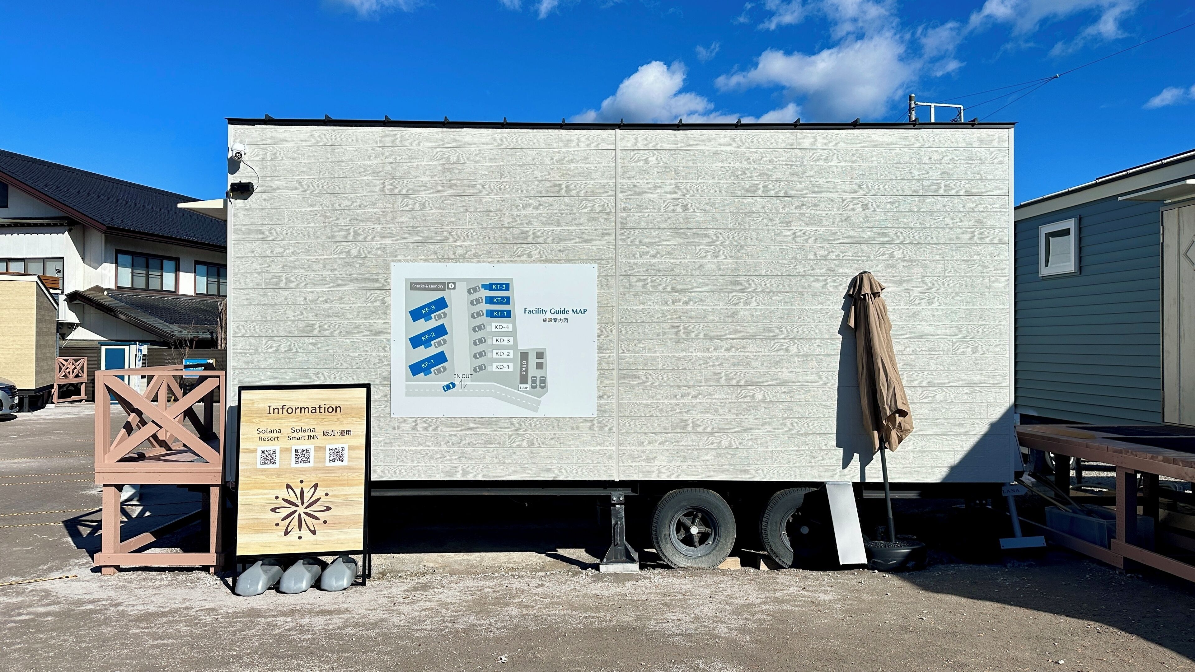 Un edificio grande, blanco y rectangular con un mapa informativo del lugar en su lateral.