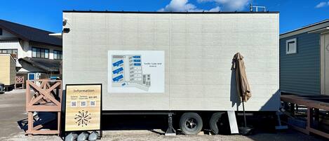 Un edificio grande, blanco y rectangular con un mapa informativo del lugar en su lateral.