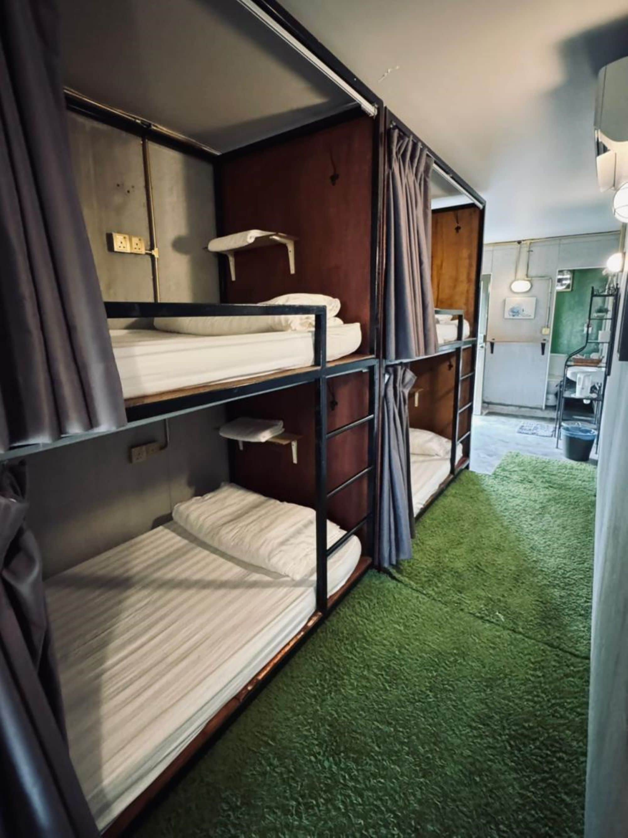 Ein kleines Zimmer mit Etagenbetten, einer kleinen Küchenzeile und einem Badezimmer.