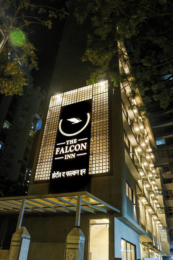 A hotel sign with a bird logo, indicating it's 'The Falcon Inn.'