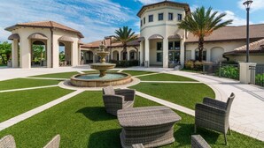 A courtyard with a fountain, outdoor seating, and a building with arches. - 1426 Wexford WAY Davenport, 8bed (Davenport)