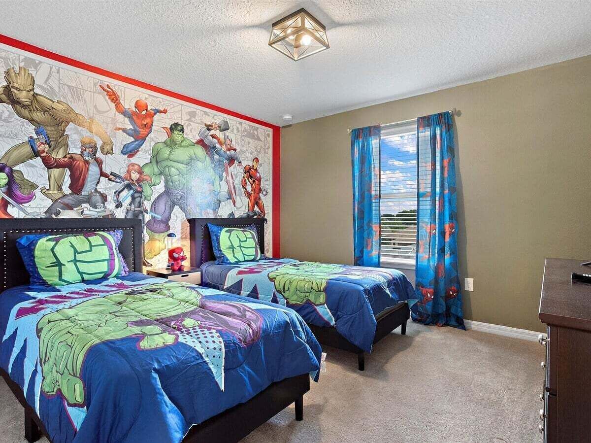 Ein Schlafzimmer mit zwei Betten, einem Wandgemälde und einem Fenster mit Vorhängen.