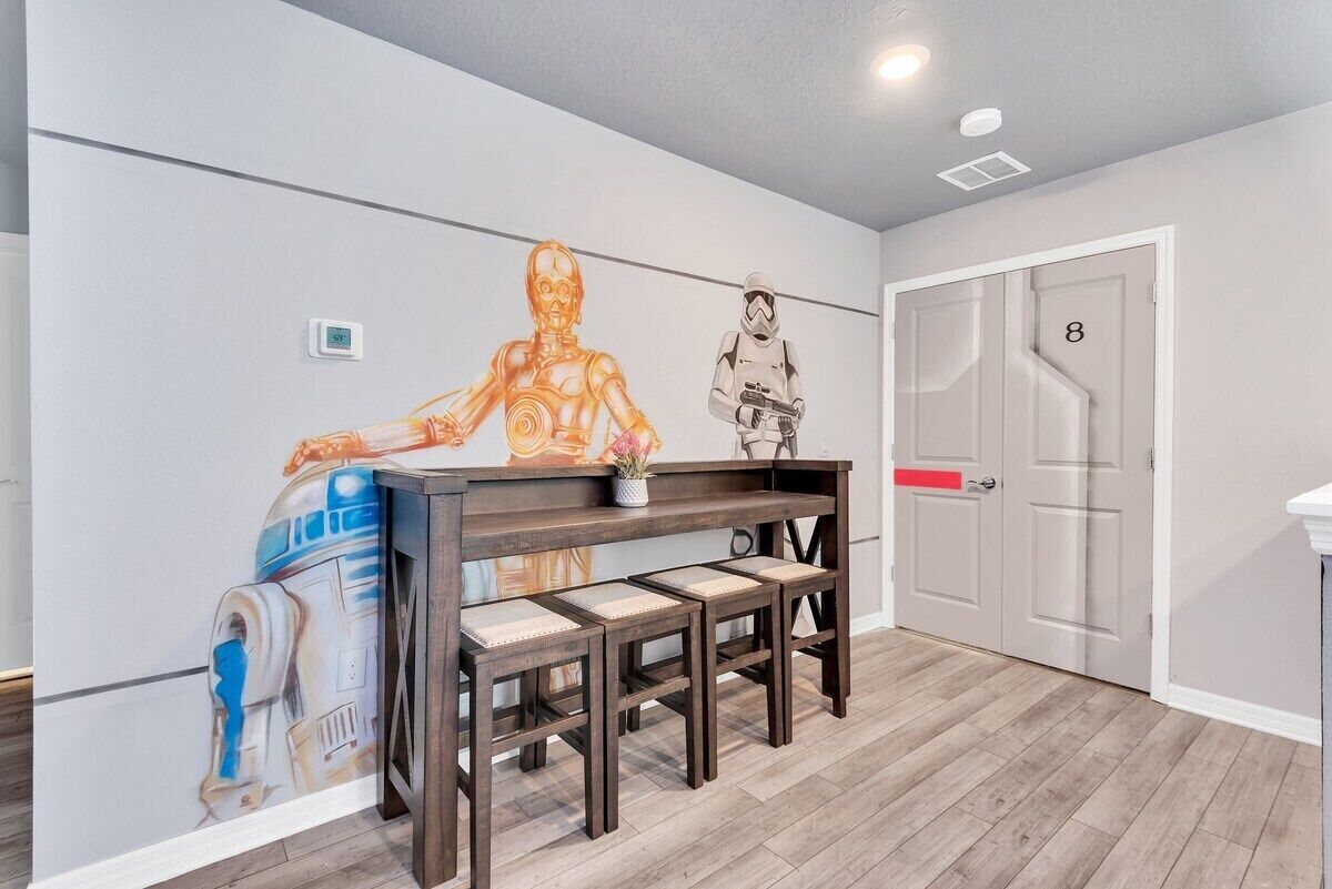 A room with a wooden bench, a wall with Star Wars-themed artwork, and a door marked with the number 8.