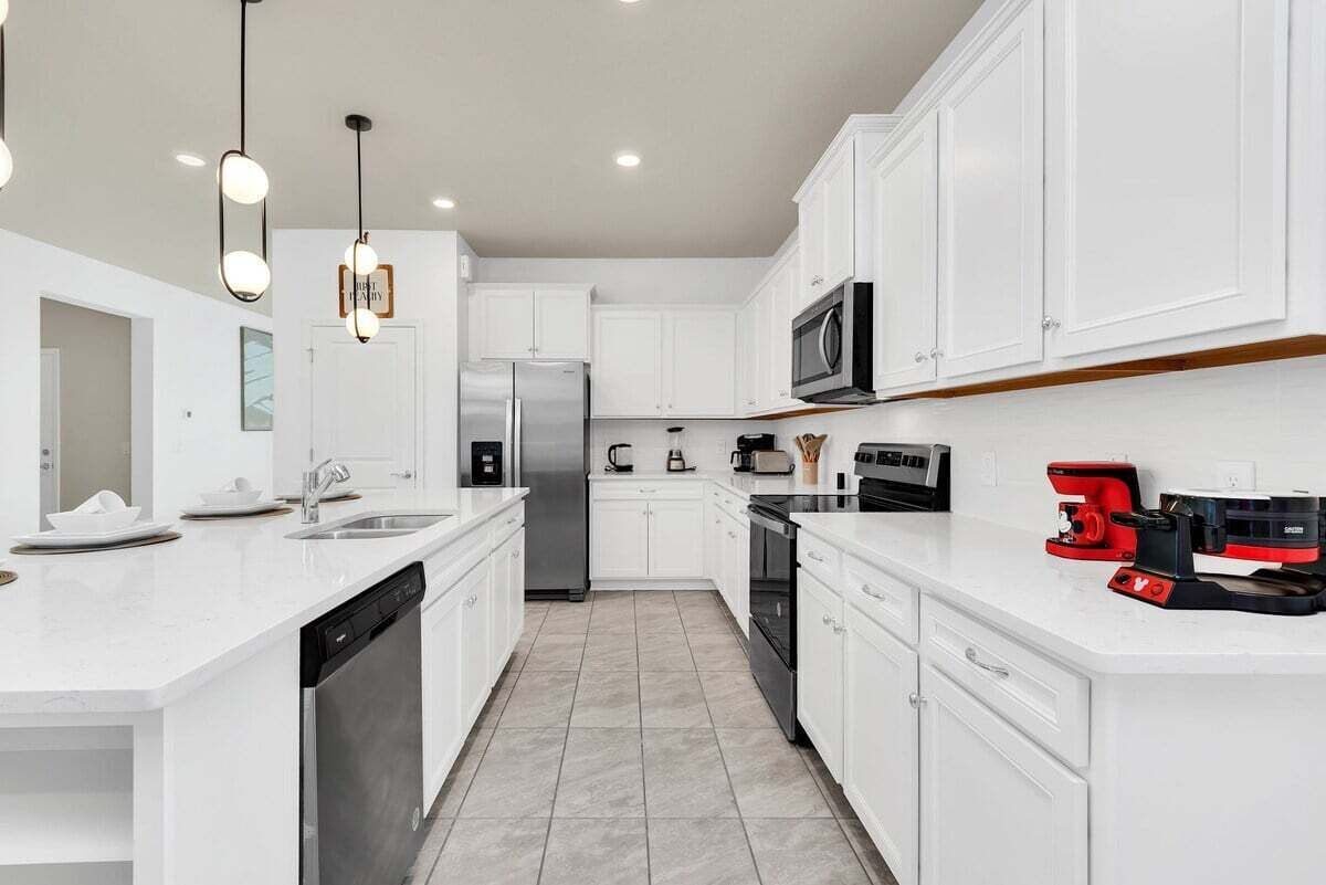 A modern kitchen with white cabinetry, stainless steel appliances, and a dishwasher.