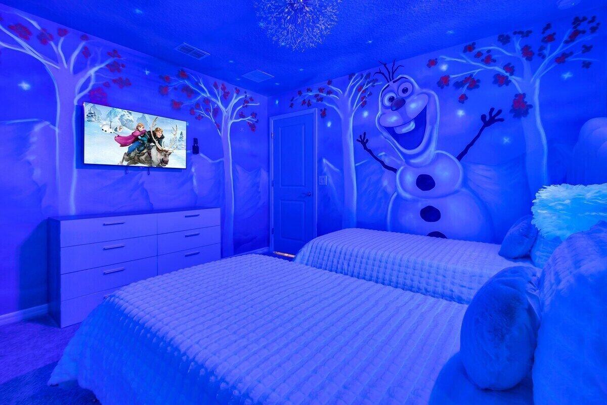 Un dormitorio con cama, cómoda y televisión en la pared.