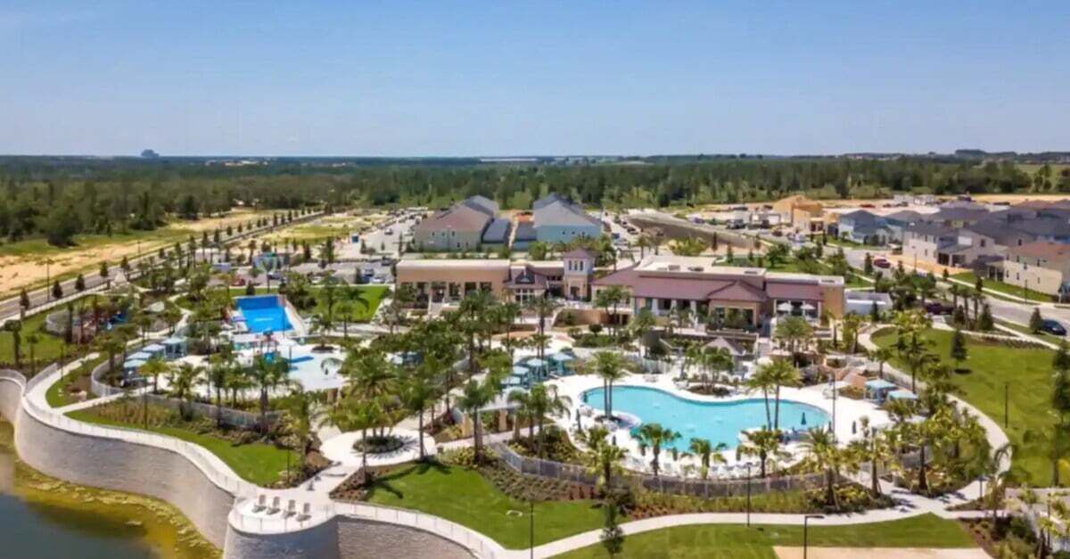 Ein Resort mit mehreren Gebäuden, einem großen Schwimmbecken und einer umliegenden angelegten Grünfläche.
