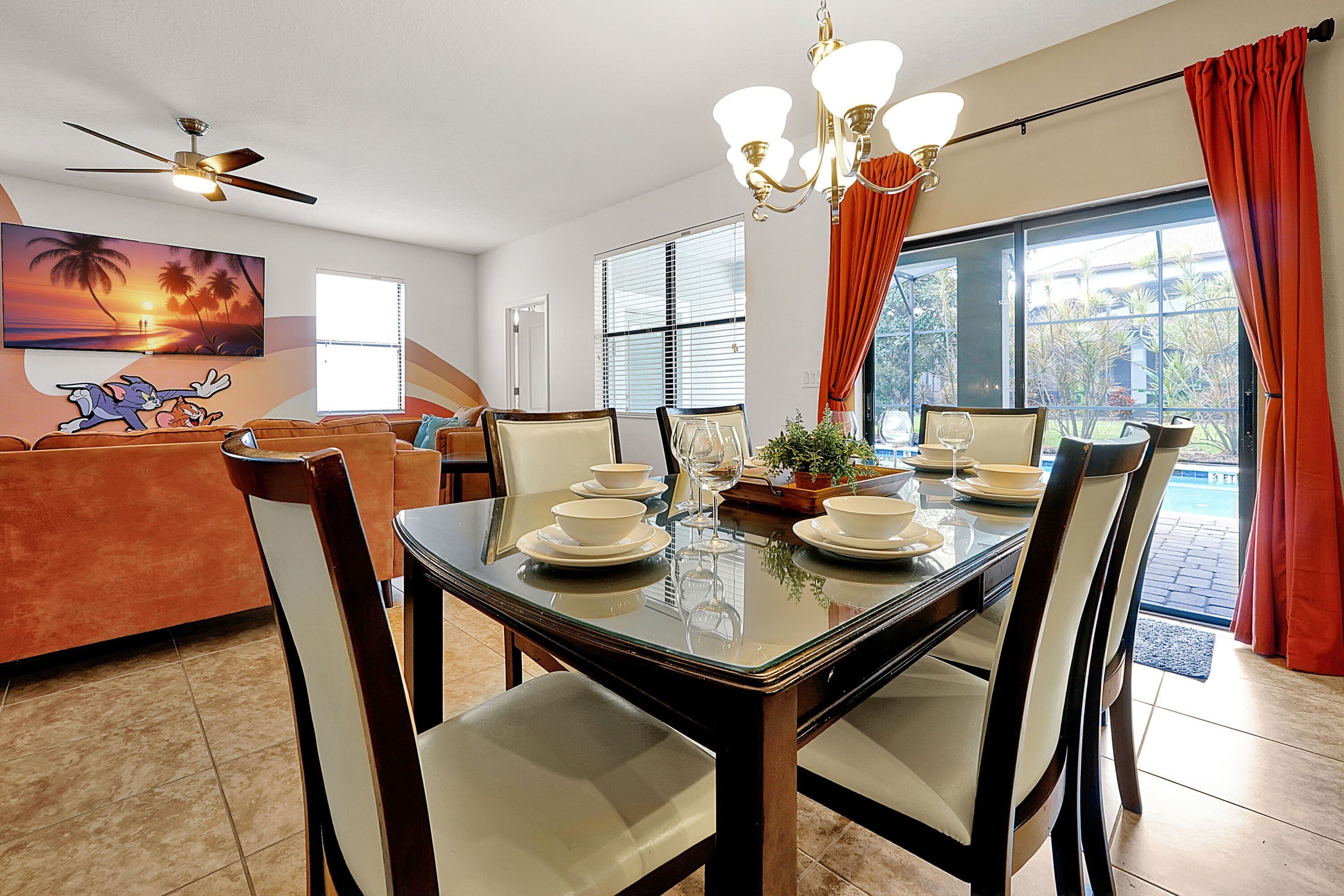 A dining area with a glass-top table set for four, surrounded by chairs.
