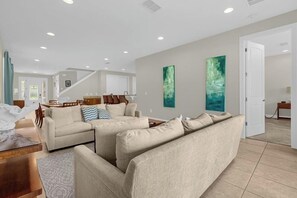 A spacious living room with a beige sofa set, a wooden coffee table, and a staircase leading to another level. - 541-7-ld-dream Home - Private Pool&spa (Kissimmee)