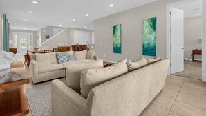 A spacious living room with a sofa set, a dining area, and a staircase leading to another level. - 541-7-ld-dream Home - Private Pool&spa (Kissimmee)