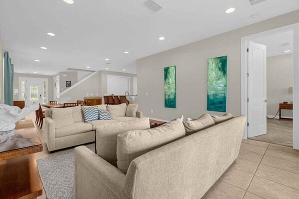 A spacious living room with a sofa set, a dining area, and a staircase leading to another level. - 541-7-ld-dream Home - Private Pool&spa (Kissimmee)