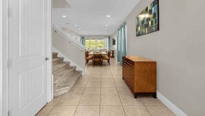 A spacious hallway with a staircase, a dining area, and a wooden cabinet. - 541-7-ld-dream Home - Private Pool&spa (Kissimmee)