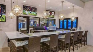 Una cucina moderna con isola centrale, illuminazione a sospensione e decorazioni a tema sportivo.