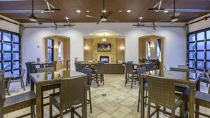 Un ristorante con tavoli e sedie alti, uno schermo televisivo e un caminetto.