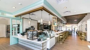 A modern hotel lobby with a central bar area, seating, and a reception desk. - 8950cbd · Amazing 9BR Lakeview Villa in Solara With Pool/spa (Kissimmee)