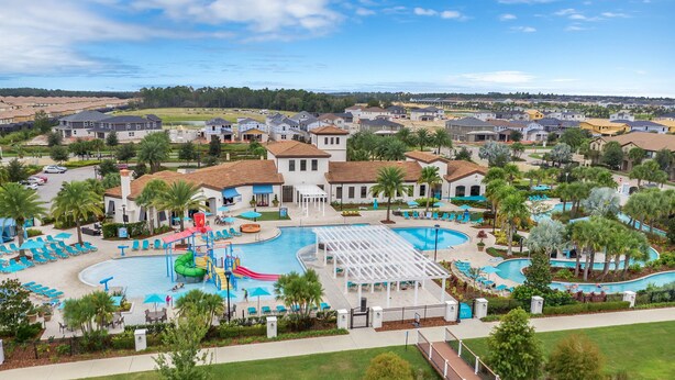 Un resort con un amplio área de piscina, numerosas tumbonas y un pabellón.