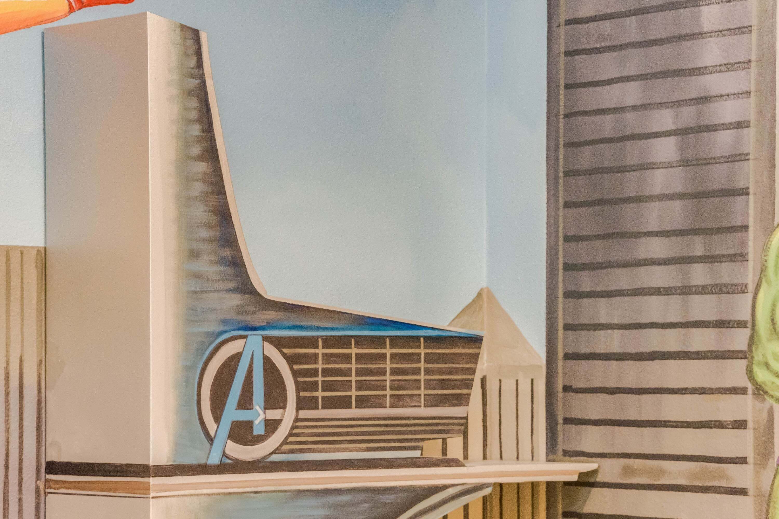 Une façade de bâtiment moderne, ornée d’un logo en forme de « A » bien visible, d’un toit en pente et d’un motif de bandes verticales.