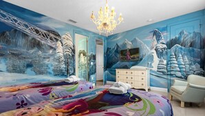 Een slaapkamer met een groot bed, een kaptafel, een stoel en een kroonluchter.