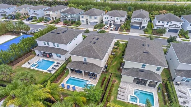 Een woonwijk met moderne huizen, een zwembad en verzorgde groenvoorziening.