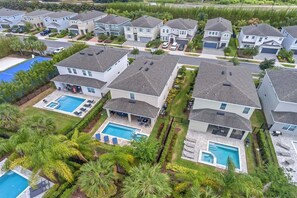 A residential area with modern houses, a swimming pool, and well-maintained landscaping. - 7601-7-bl-designer Decorated With Whimsical Themed Rooms (Kissimmee)
