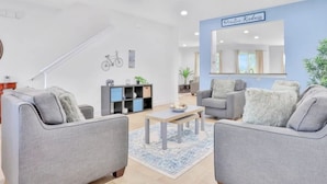 Ein modernes Wohnzimmer mit grauen Sofas, einem Couchtisch und einem Bücherregal.