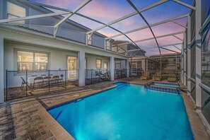 Una piscina con techo de cristal, asientos exteriores y vistas al cielo.